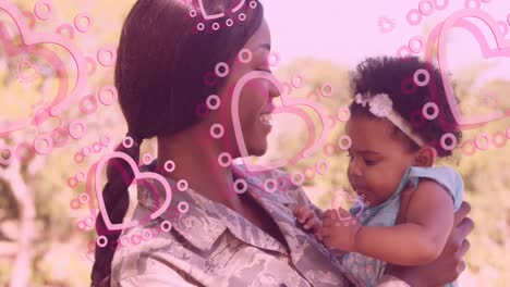 Animation-of-hearts-over-happy-african-american-soldier-mother-hugging-daughter