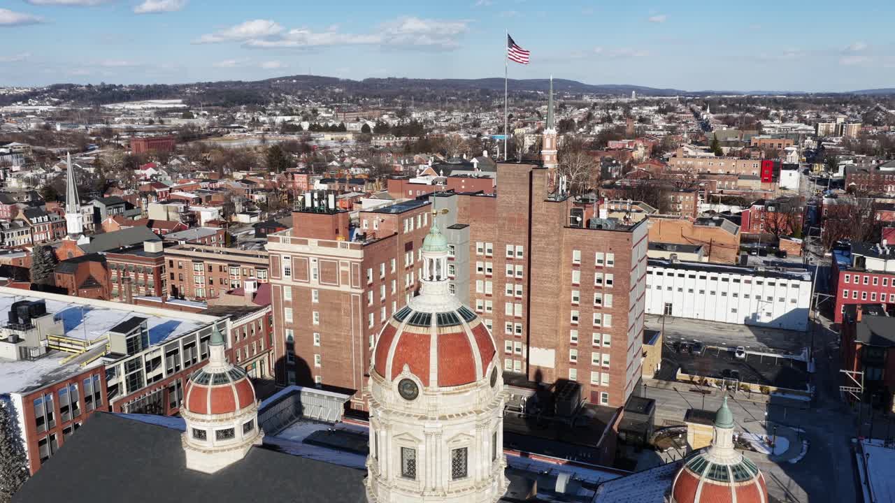 Flyfoto av historiske York, Pennsylvania, med kirketårn, mursteinsbygninger og amerikansk flagg som vaier over sentrum på en klar solskinnsdag. Tinghuset i York County i den historiske byen i USA.