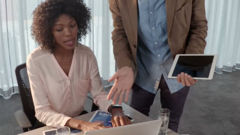 businessman discussing with his coworker over laptop