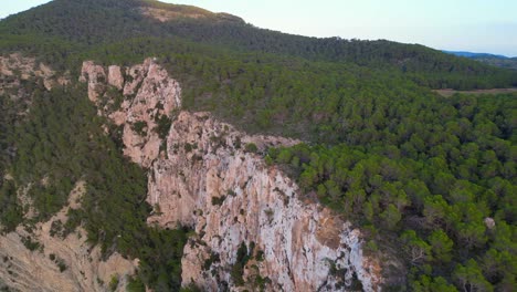 Couple-picnic-on-cliff-edge-with-a-view-of-the-green-landscape-during-sunset-in-ibiza