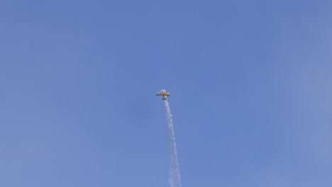 a stunt plane executes loops and dives in the sky