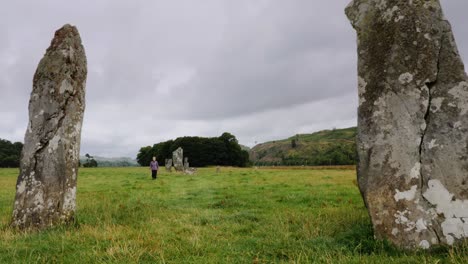 Lady-walks-through-standing-stones-in-Kilmartin-Glen