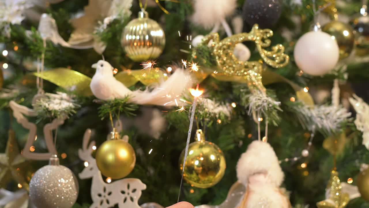 fuego de brillo festivo ardiendo frente al árbol de navidad decorado de oro blanco. cámara lenta