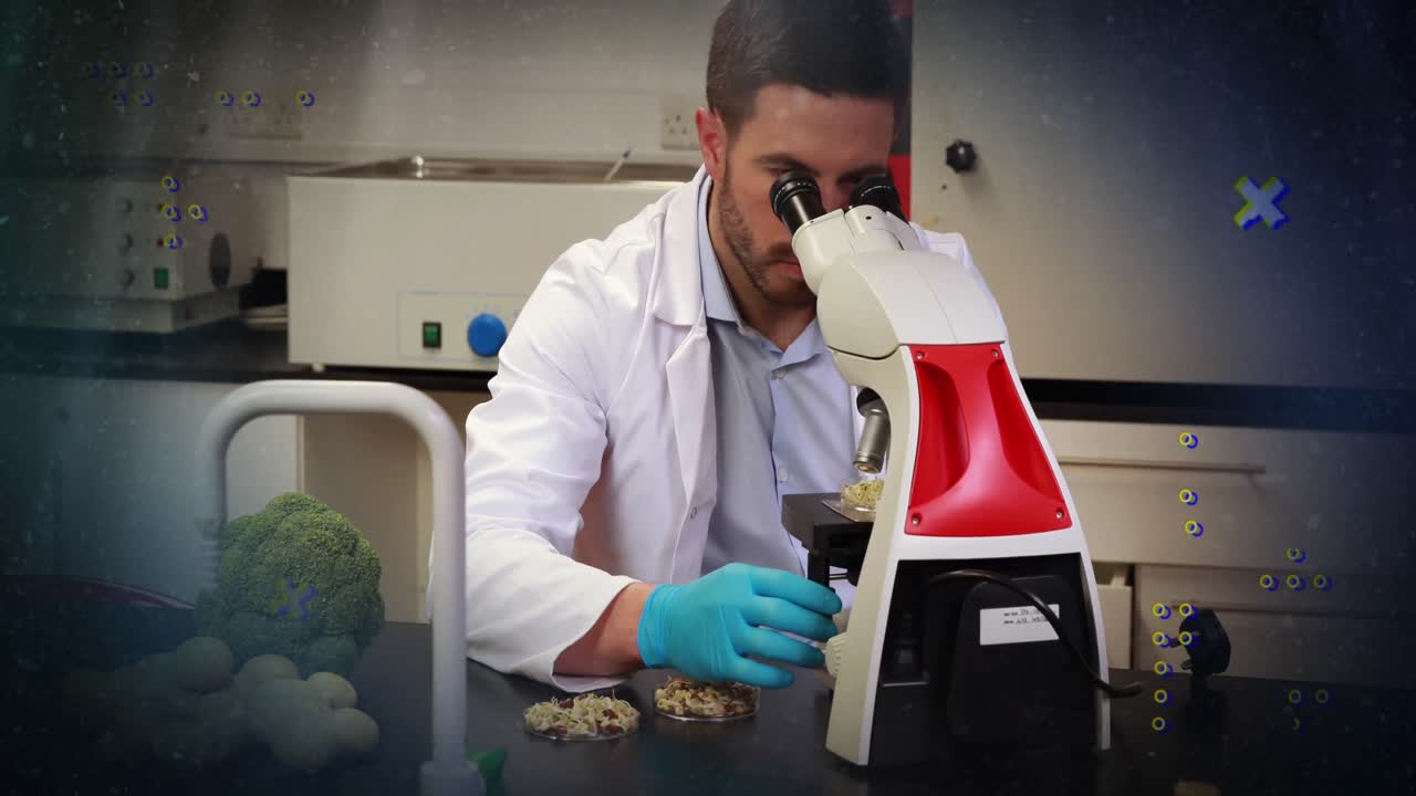 Animation of abstract shapes against caucasian male scientist using microscope at laboratory