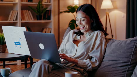 happy woman working on her laptop in a cozy home setting