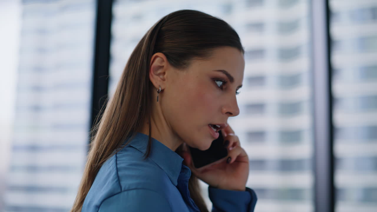 employee calling mobile phone by window closeup. Businesswoman talking