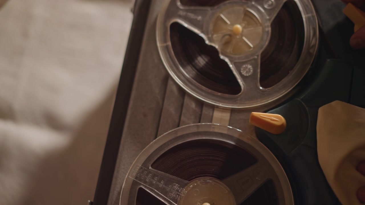 Close look at vintage devices. Inspecting classic machinery and reel mechanisms thoroughly. Careful inspection and analysis of old tape players and their delicate internal components