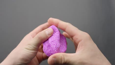 hands squeeze purple floam slime, showing texture in a stress-relief moment
