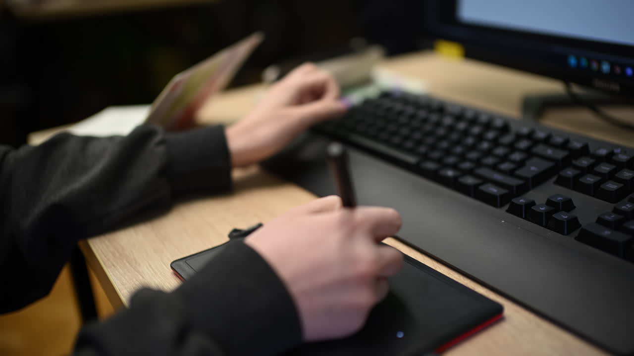 Persona che usa una tavoletta grafica collegata a un computer per lavoro di design digitale.