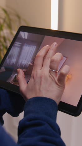 person interacting with a tablet displaying a 3d home design