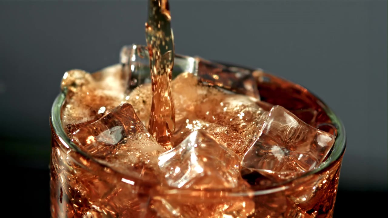 Bevanda gassata rinfrescante versata su ghiaccio in un bicchiere