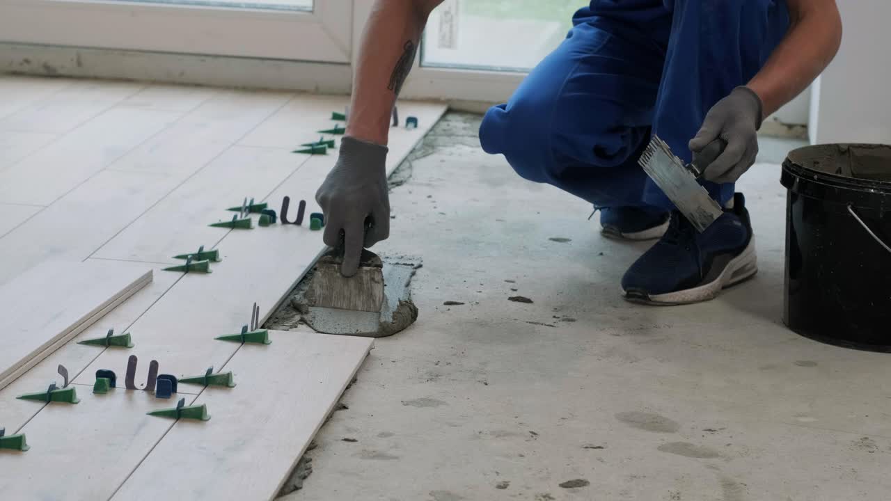 Installing ceramic floor tiles - measuring and cutting the pieces. Construction, renovation, repair apartment. Cuts tile. Tile cutting