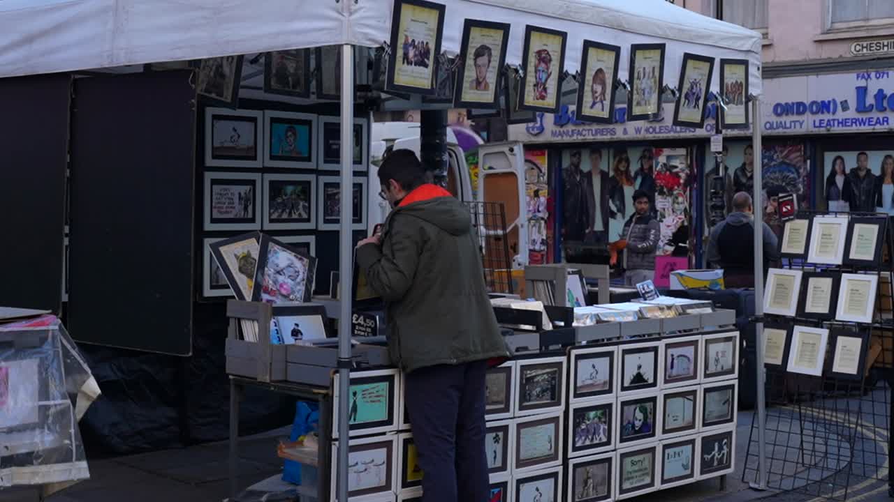 Man Browsing Art Prints at a London Street Market
