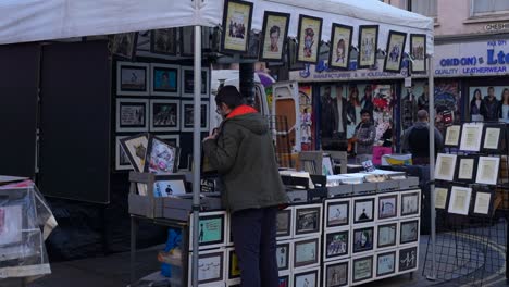 man browsing art prints at a london street market