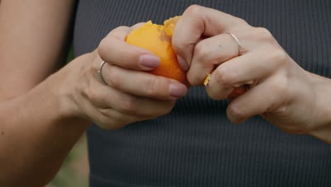 una mujer pelando una naranja.