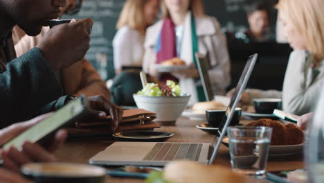 businessman hands using laptop computer in cafe typing emails working online enjoying drinking coffee relaxing on lunch in busy restaurant