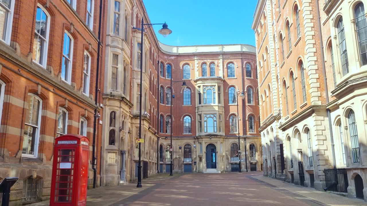 Shot of Nottingham’s historic Broadway, England, featuring timeless architecture and a classic red British phone box beneath a bright, clear sky