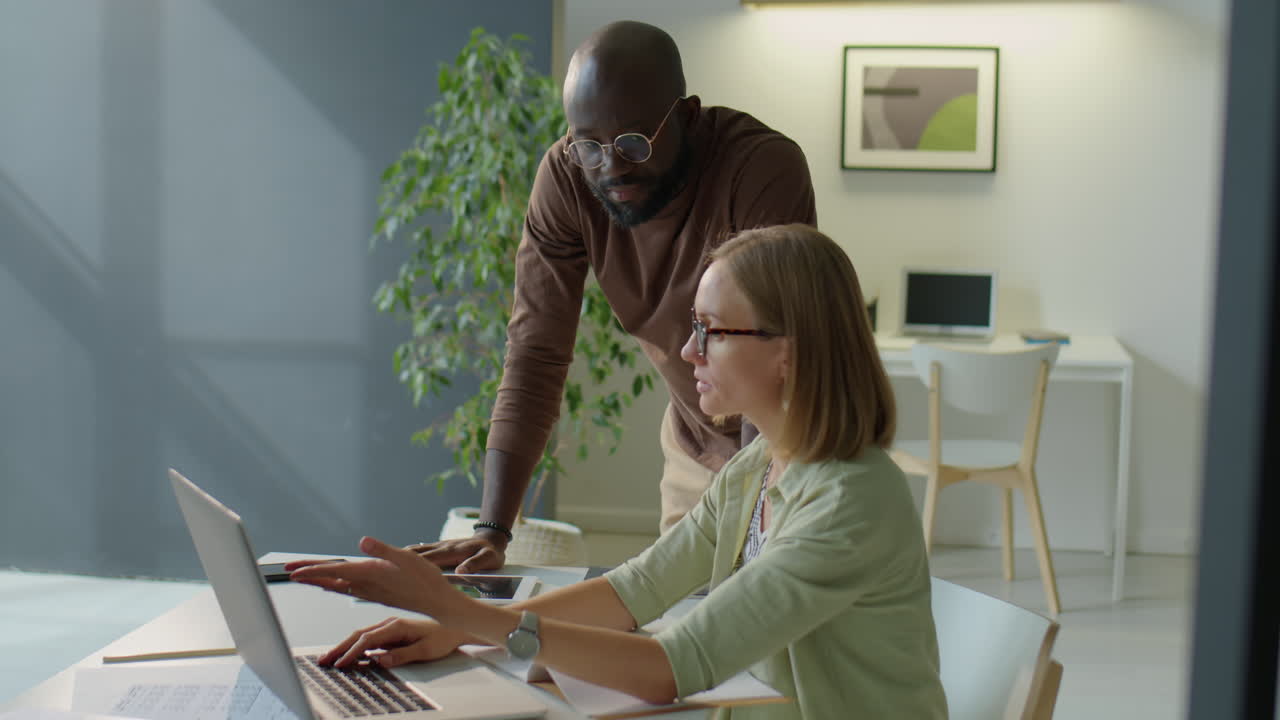Multiethnic Coworkers Discussing Project on Laptop