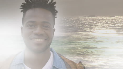 animation of smiling african american man at beach over sea