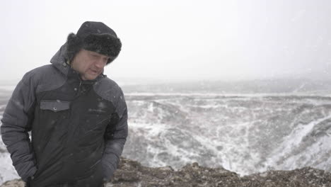 Hombre-De-Mediana-Edad-Con-Ropa-Cálida-De-Invierno-Caminando-Sobre-La-Nieve-En-El-Frío-Paisaje-De-Islandia