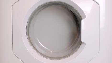 washing machine washes different clothing and sheets. cylinder spinning. nobody