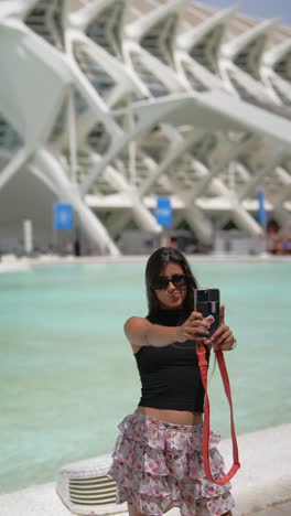 mujer tomando una selfie frente a un museo moderno