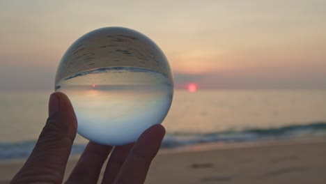 magic sunset view in a crystal ball on your hand.