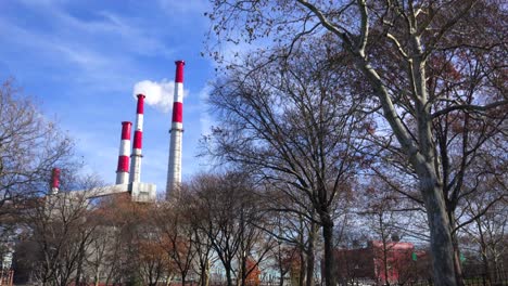 smokestacks from the ravenswood generating station in queens rise above a city park