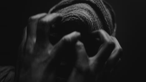 a mummy of a woman on a dark backdrop turns her head
