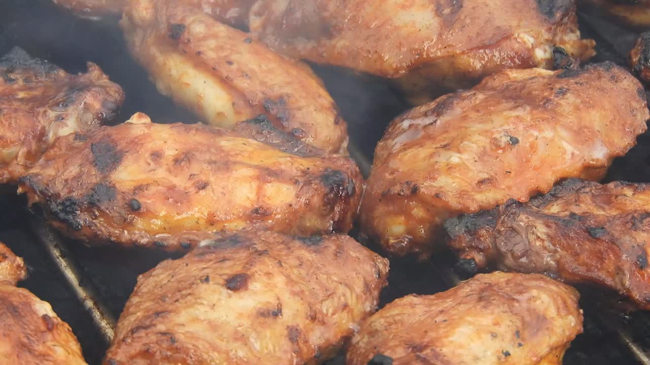 Outdoor grill with chicken wings, pork and fish under the heat of flames and smoke with nice texture and appetizing look.