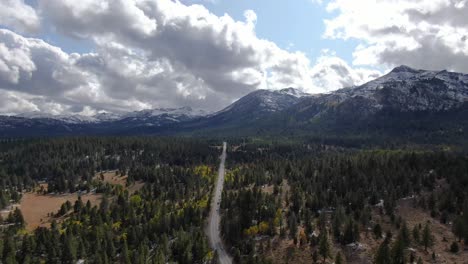 Foto-Panorámica-De-Una-Carretera-Que-Atraviesa-El-Bosque-Y-Picos-Nevados-En-El-Horizonte-En-Lake-Tahoe-En-Sierra-Nevada,-California.