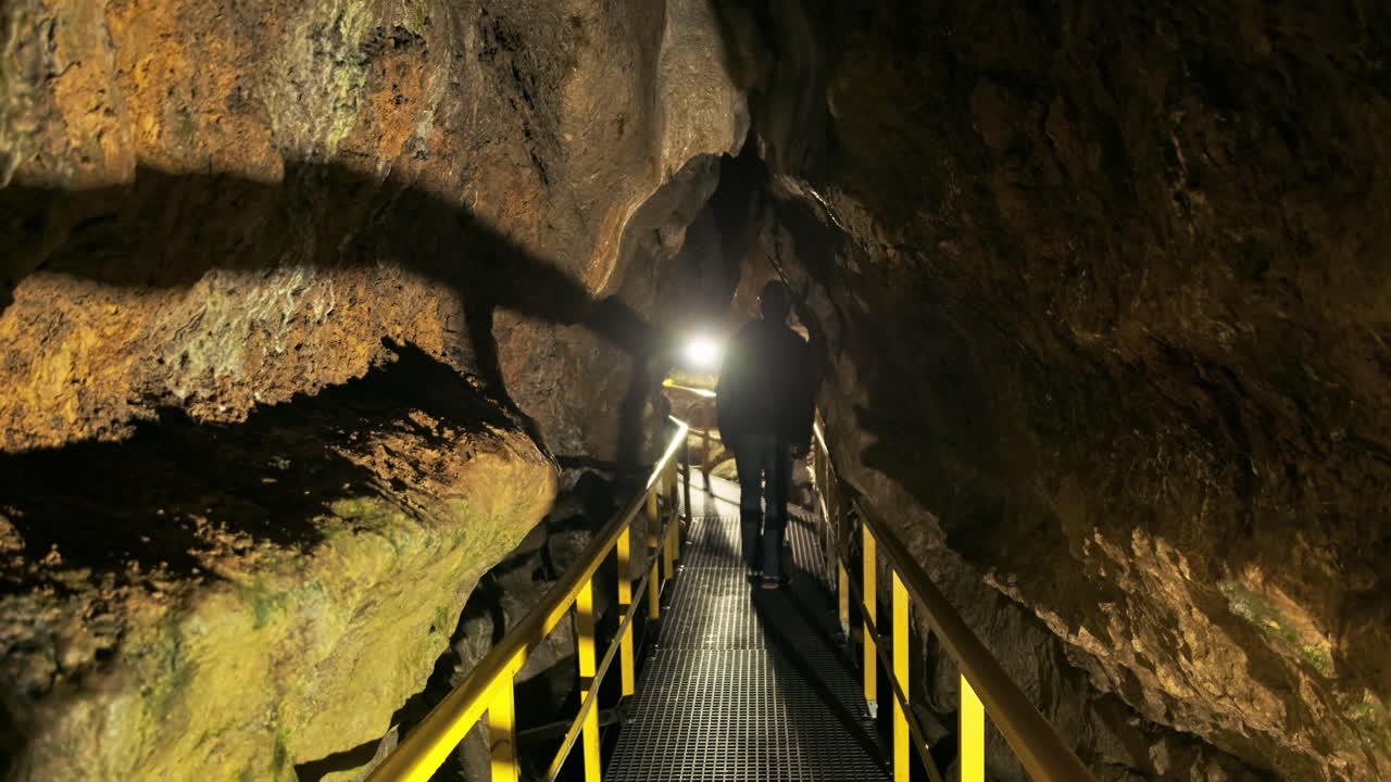 View of The Ialomitei Cave in Bucegi Mountains, Romania. Tourists, bridges, illumination