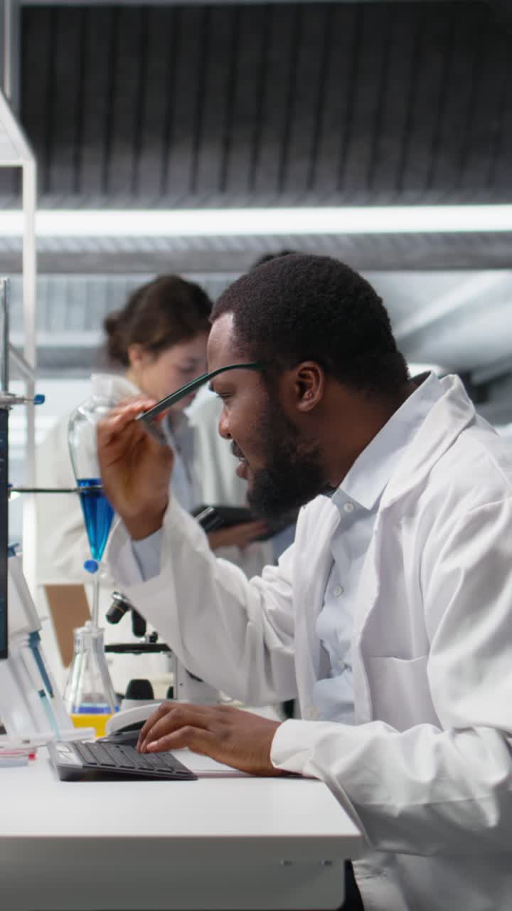 Vertical video Laboratory worker squinting eyes at computer, struggling to understand DNA data