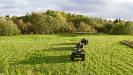 atv's in a grassy field near a forest