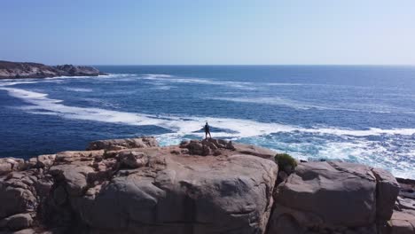 man climbing rock in the sea