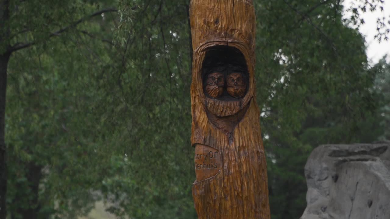 Owl nest wood carving statue on an overcast evening before dusk at Seims Park in Union, IL