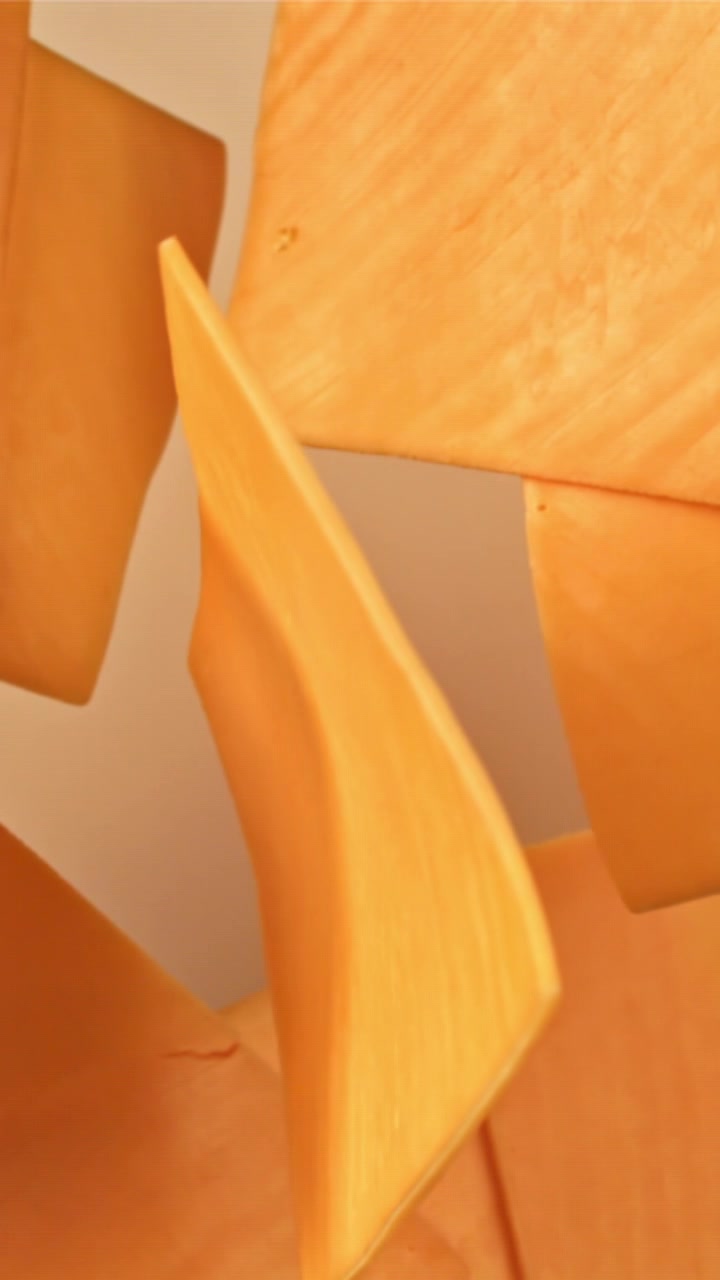 Una fetta di formaggio Cheddar arancione che ruota e si posa