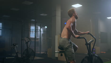 Joven-Usando-Bicicleta-Estática-En-El-Gimnasio.-Hombre-De-Fitness-Usando-Bicicleta-De-Aire-Para-Hacer-Ejercicio-Cardiovascular-En-El-Gimnasio.-Esfuerzo-Del-Equipo.