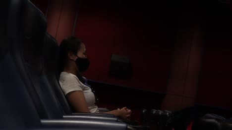 tired woman feeling sleepy while watching alone in the cinema, side view, static