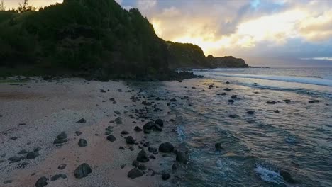 flying-low-over-the-beach-along-the-ocean-on-the-coast-of-Maui-Hawaii-during-sunset,-dolly-forward