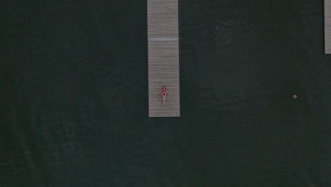 aerial rocket shot of the young women enjoying a summer day on a dock