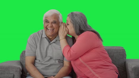 Happy-Indian-old-wife-telling-a-secret-to-her-husband-in-ear-Green-screen