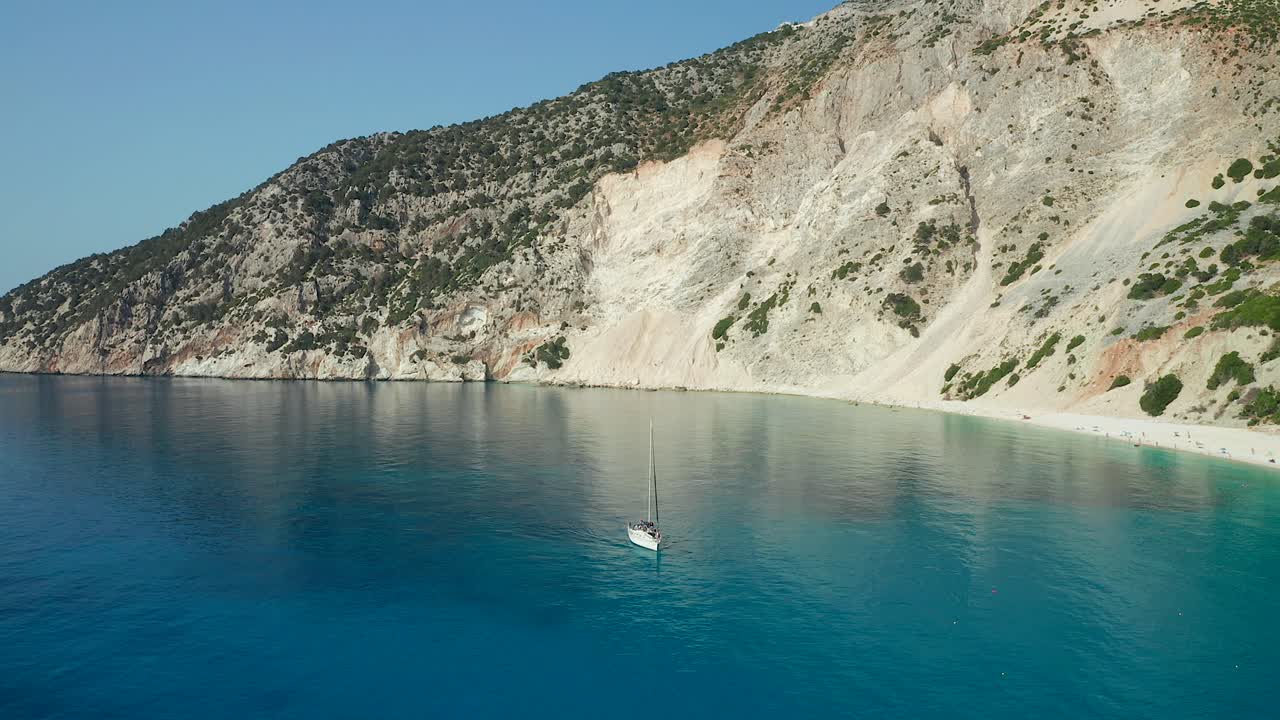 Aerial view Sailing boat on emerald water over scenic Cliffs at Myrtos beach, Greece