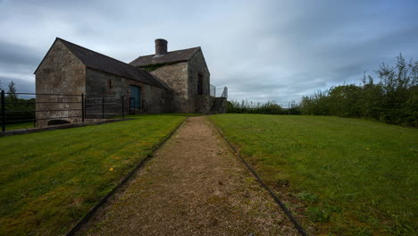 time lapse of a historical lime kiln building during the day with passing clouds in rural landscape ireland