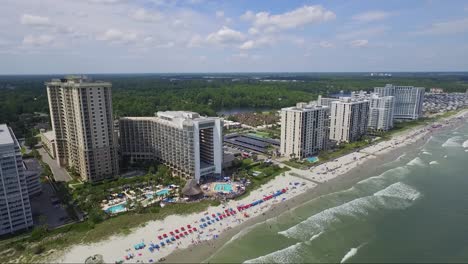 Slow-panning-shot-of-tall-resorts-on-the-beach-in-summer