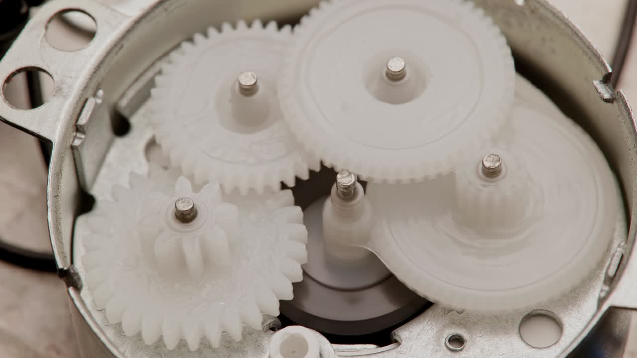5개의 플라스틱 기어가 작은 감소 기어 안에서 상호 메쉬로 회전합니다.