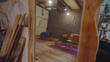 Wide-view-of-artist-assembling-shelf-made-from-upcycled-wood-and-iron