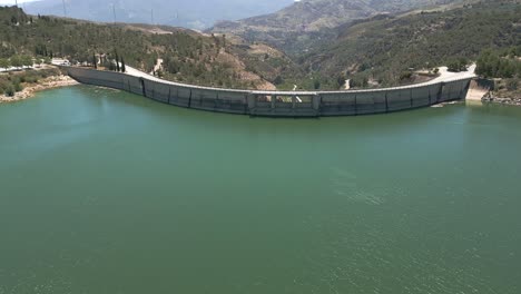 vault dam. panoramic aerial view in ascend of road over curved dam. spain.