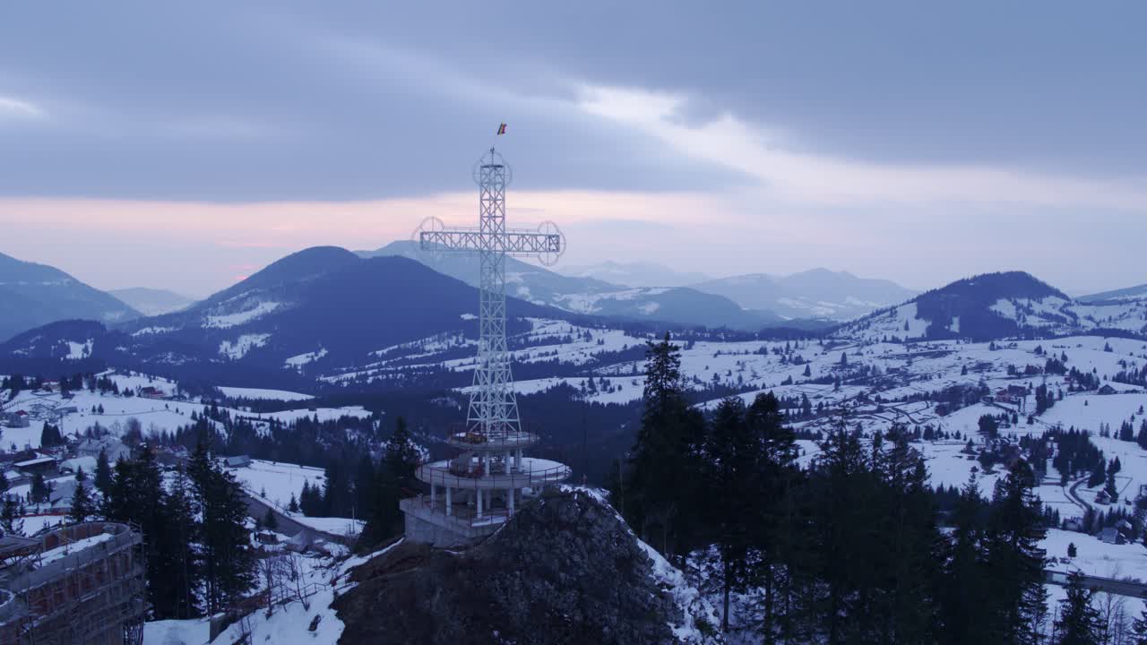 Aerial shot of a cross-shaped monument on a mountain. Tihuta Pass, Bistrita - Nasaud, Romania