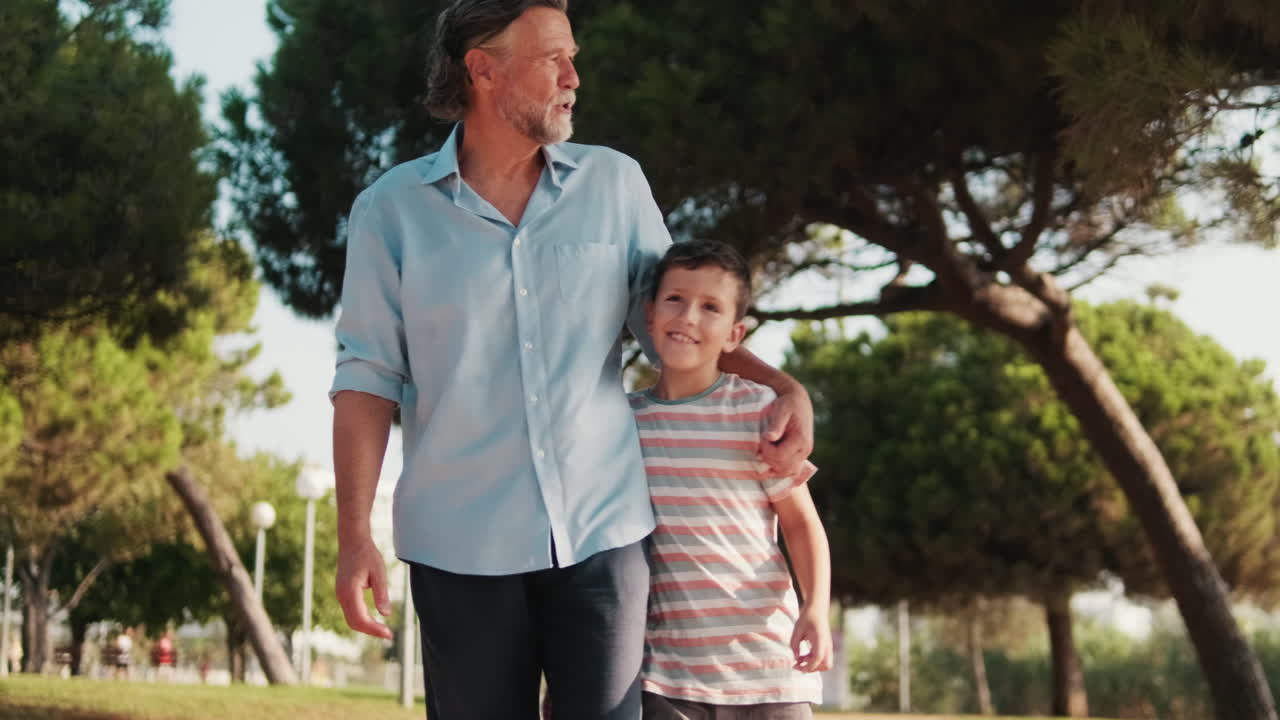 Hombre y niño felices caminando juntos en un parque soleado